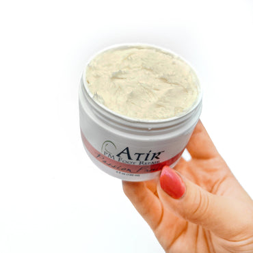Open jar of PM Foot Repair Cream in woman's hand, soft, fluffy peaks of buttery cream.