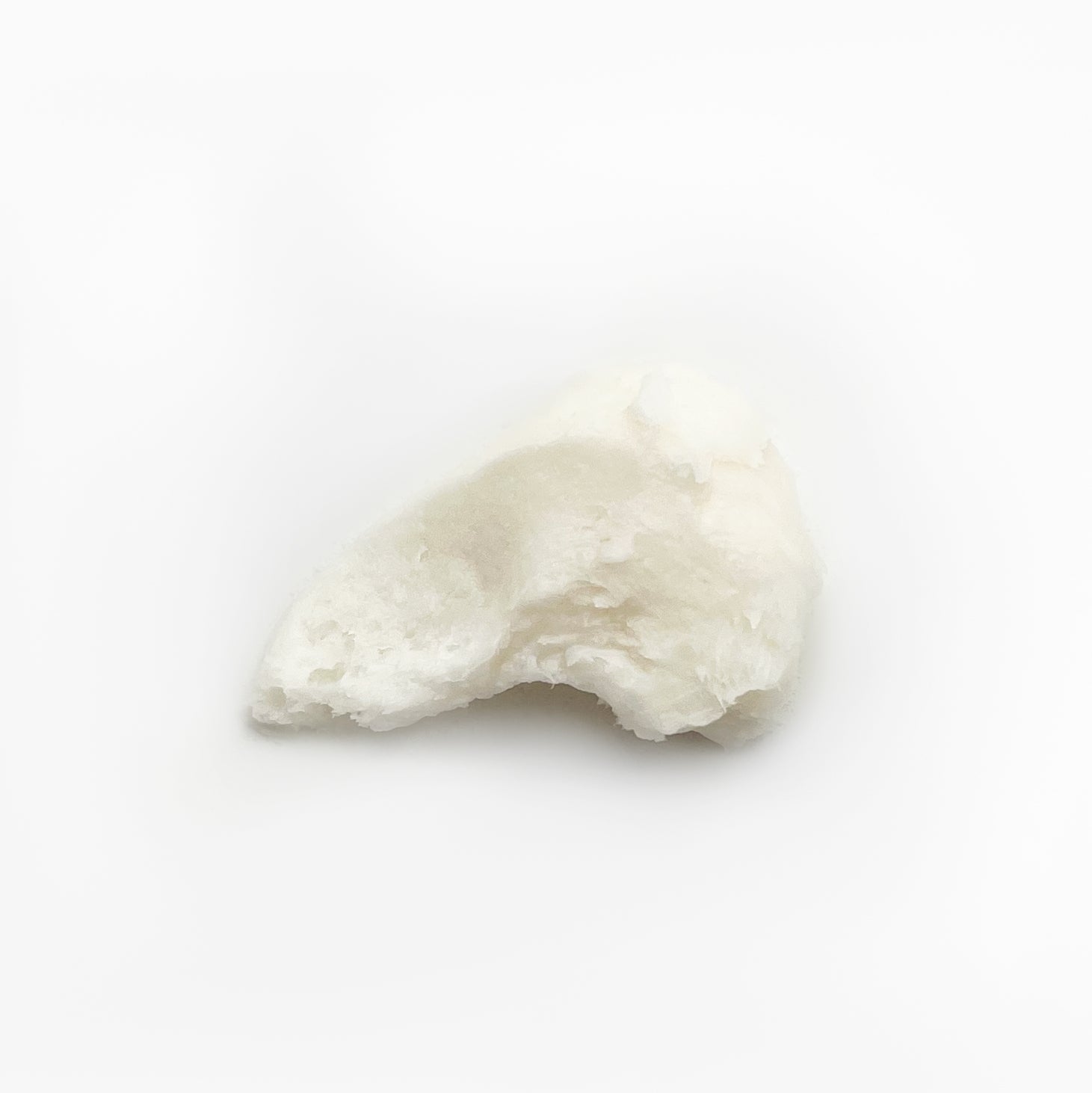 Swirl of thick, buttery PM Foot Repair cream on white background